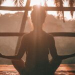 woman doing yoga meditation on brown parquet flooring